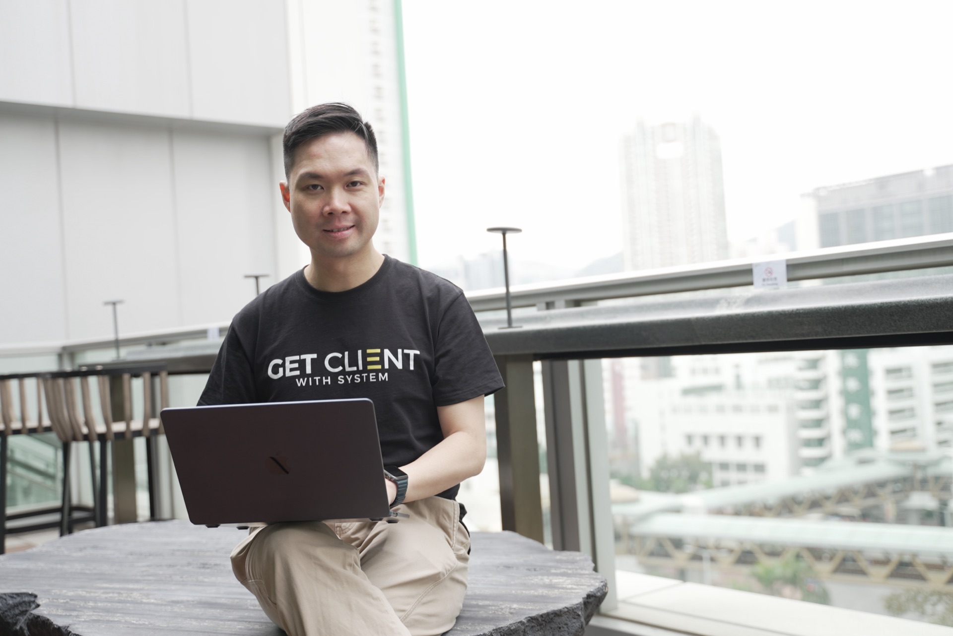 Nic Leung 在露台用手提電腦工作