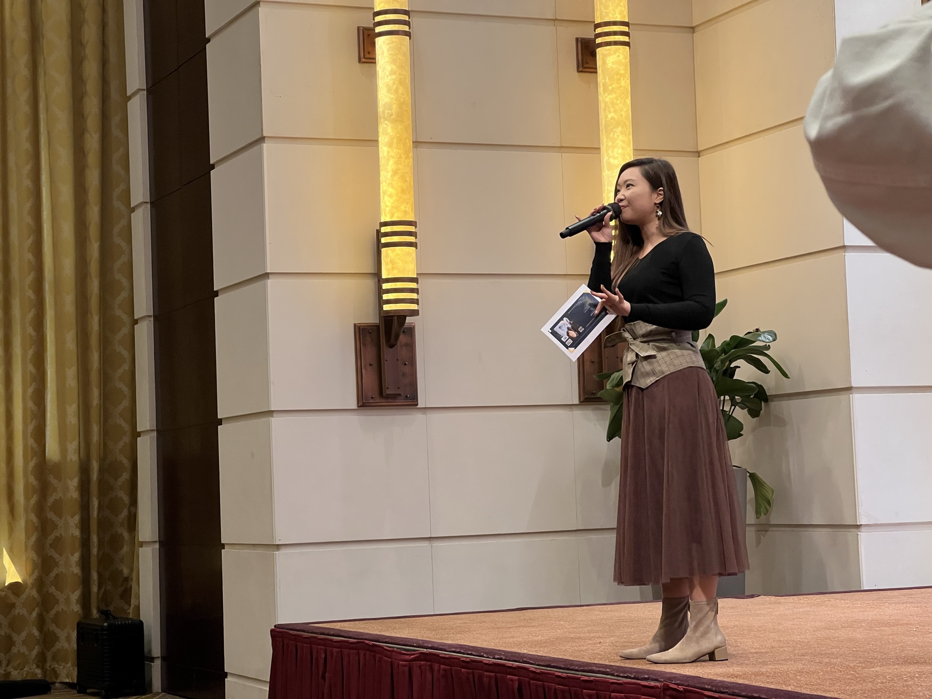 April Lo 在舞台上手持咪高峰演講