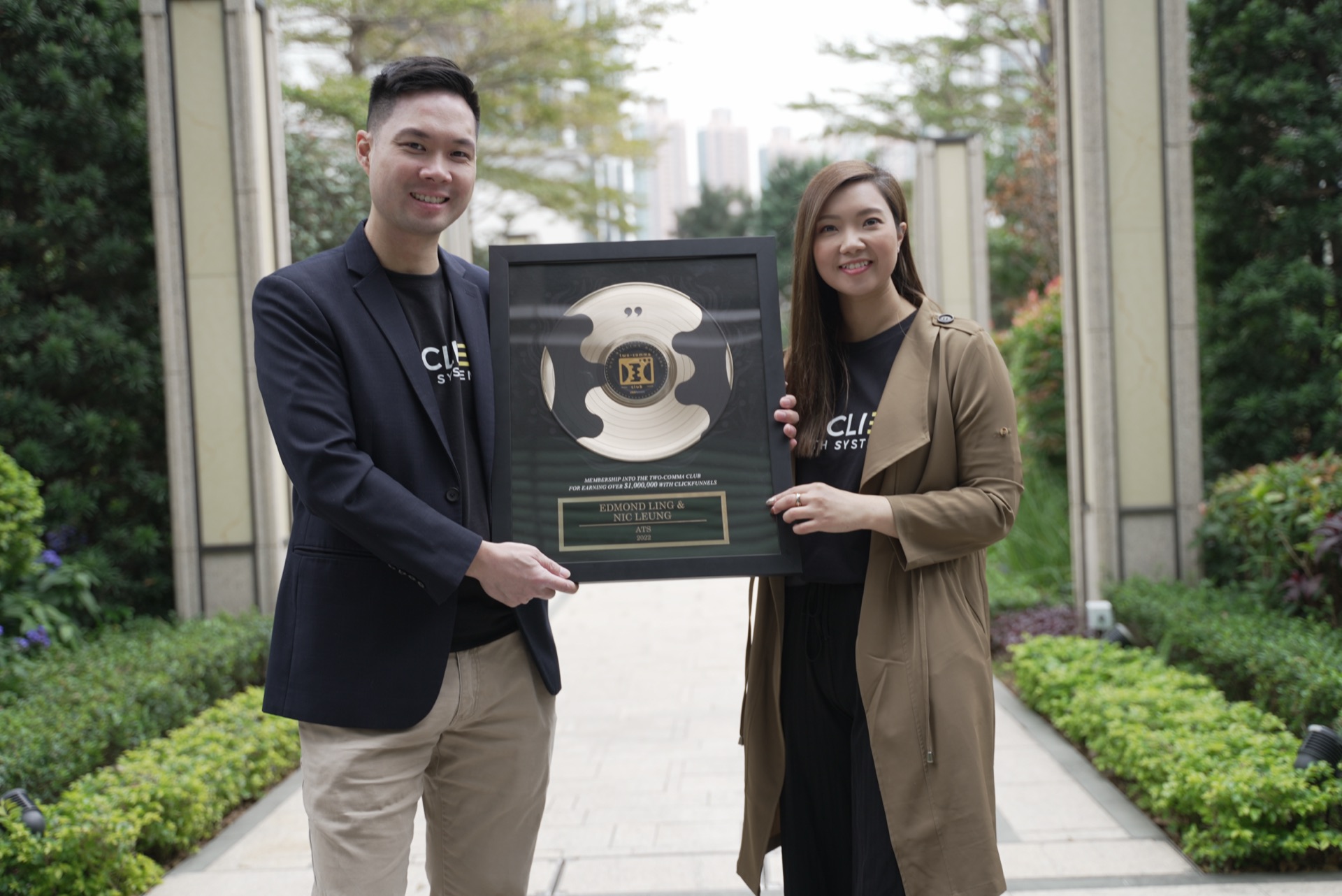 Nic Leung 與 April Lo 在戶外手持 Two Comma Club 獎座